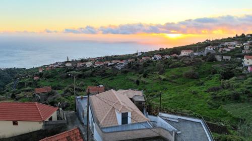 a view of a town on a hill with the ocean at Blue Horizon, Sea and Mountain view in Estreito da Calheta