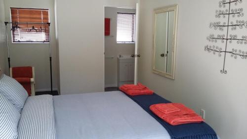 a bedroom with a bed with two red pillows on it at Jan's Boutique B & B Suite in Christchurch