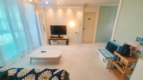 een woonkamer met een bank en een tv bij Yangyang Shim Stay in Yangyang