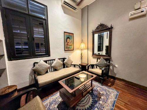 a living room with a couch and a table at Museum Hotel in George Town