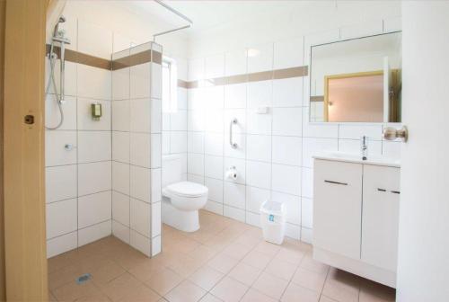 Baño blanco con aseo y lavamanos en A & A Motel en Proserpine
