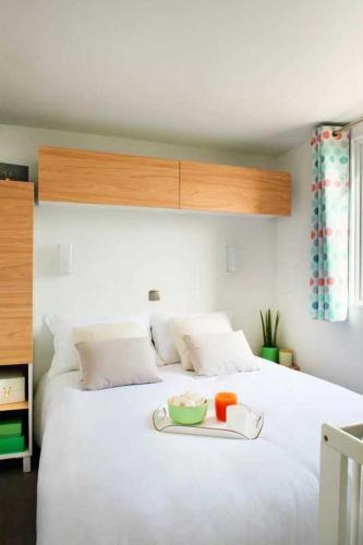 - un lit blanc avec un plateau/bouilloire dans l'établissement Camping 4 étoiles - Piscine - eeieih, à Saint-Jean-de-Monts