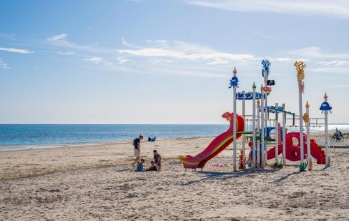 a group of people on a beach with a playground at Apartment Laguna Azul in El Mojón