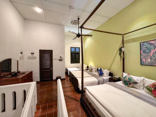 a room with three beds in a room at Museum Hotel in George Town
