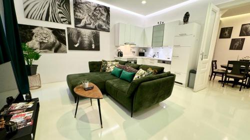 a living room with a green couch and a table at African Paradise with Jacuzzi & Sauna in Vienna