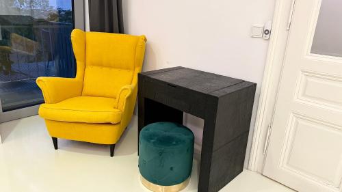 a yellow chair sitting next to a table and a yellow chair at African Paradise with Jacuzzi & Sauna in Vienna