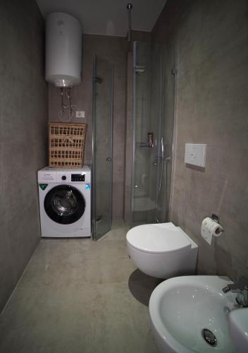 a bathroom with a washing machine and a toilet at Center Oasis Appartmens in Tirana