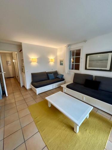 un salon avec deux canapés et une table basse dans l'établissement Apartment T3 - area with pool and activities, à Urrugne