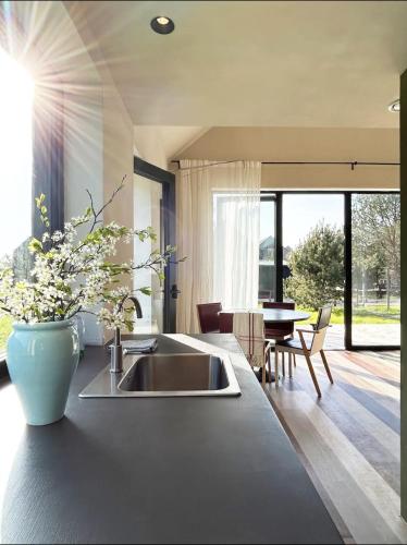 a kitchen with a sink and a table with chairs at Laimingi namai in Palanga
