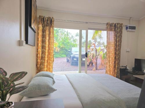 a bedroom with a bed and a sliding glass door at Seaside Exotic Studio in Suva City Quality bedding free wifi n parking in Suva