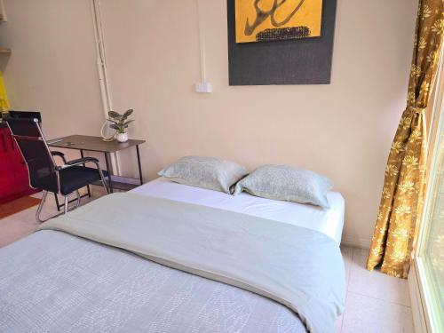 a bedroom with a bed and a table with a chair at Seaside Exotic Studio in Suva City Quality bedding free wifi n parking in Suva