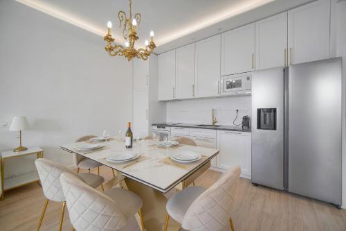 - une cuisine blanche avec une table à manger et des chaises dans l'établissement Exceptionnel 4 pieces balcon carre d or A3B129, à Cannes