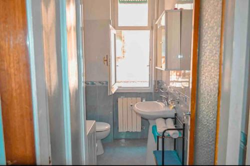 a bathroom with a sink and a toilet and a window at House of the sea in Chiavari