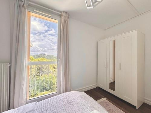 - une chambre blanche avec une grande fenêtre et un lit dans l'établissement Bel appartement lumineux Aix, à Aix-en-Provence