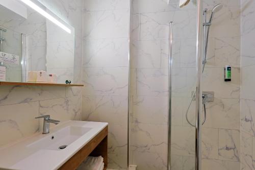 a bathroom with a sink and a shower at Logis Hôtel & Restaurant Mediterranee in Port-la-Nouvelle