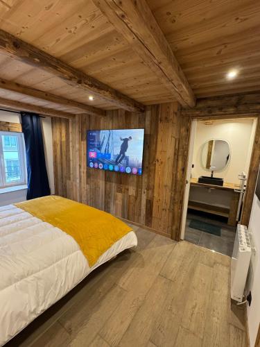 une chambre avec un lit et une télévision sur un mur dans l'établissement Le grand cerf, à Gérardmer