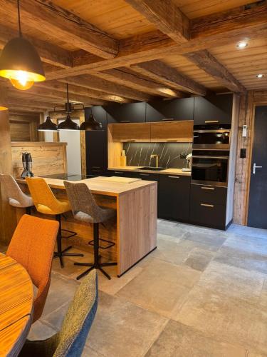 une cuisine avec une table et des chaises en bois dans l'établissement Le grand cerf, à Gérardmer