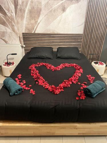 - un lit avec un cœur en fleurs rouges dans l'établissement La Suite Nayara, à Saint-Germain-sur-Morin