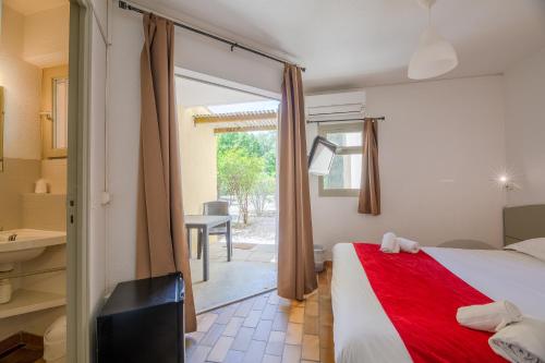 a bedroom with a bed and a bathroom with a window at Marina Hôtel Club in Cogolin