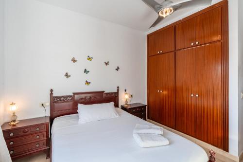 a bedroom with a large bed and a wooden cabinet at Beach House Roda de Bera in Roda de Bará