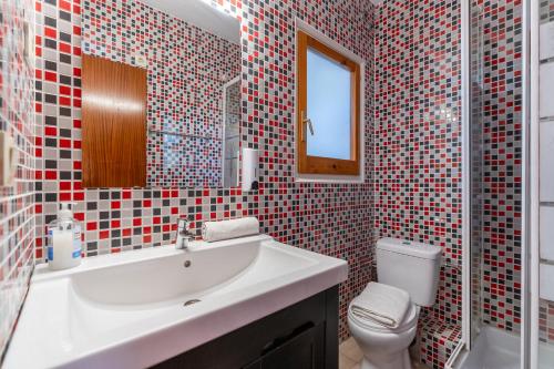 a bathroom with a sink and a toilet and a mirror at Beach House Roda de Bera in Roda de Bará