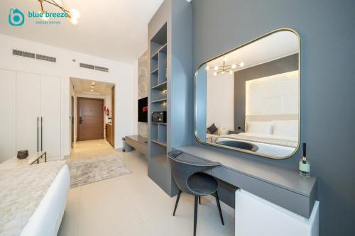 a bathroom with a mirror on a blue wall at Blue Breeze - Trendy Studio with Balcony & Stylish Interiors in Dubai