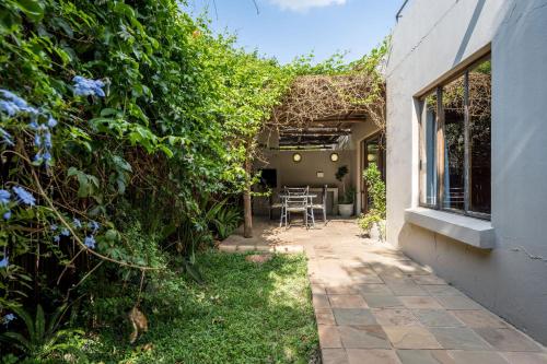 a garden with a patio with a table and chairs at Raptors Wildlife Escapes in Hoedspruit