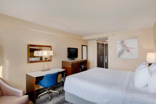 a hotel room with a bed and a desk and a tv at Crowne Plaza Hotel Harrisburg-Hershey by IHG in Harrisburg