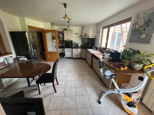 - une cuisine avec une table et un vélo dans la chambre dans l'établissement Villa avec piscine, à Châteauneuf-de-Gadagne