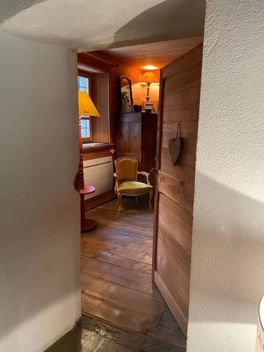 - un couloir avec une porte et une chaise dans la chambre dans l'établissement Serre Chevalier , Saint Chaffrey Chalet, à Saint-Chaffrey
