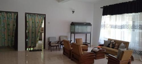 ein Wohnzimmer mit Stühlen und einem Tisch und Fenstern in der Unterkunft Coconut Breeze Villa in Mirissa