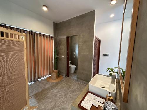 a bathroom with a sink and a toilet at Enchanted Pool Bungalows Siem Reap, right near the Wake Park in Phumĭ Kruŏs