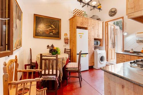a kitchen with a table and a white refrigerator at Casica de Perintín in Ojós
