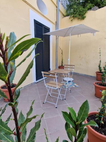 a patio with a table and chairs and an umbrella at B&B La Casa del Bellino in Vietri sul Mare