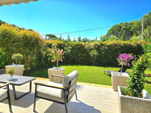 a patio with a table and chairs and flowers at Modern Villas at Perla Resort in Durrës