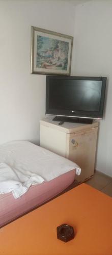 a bedroom with a tv and a bed and a table at Caglayan otel pansiyon in Bodrum City