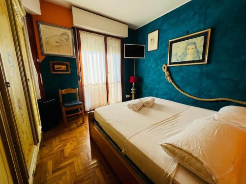 a bedroom with a bed with a blue wall at Suite Euforbia Bilo - Sanremo in Sanremo