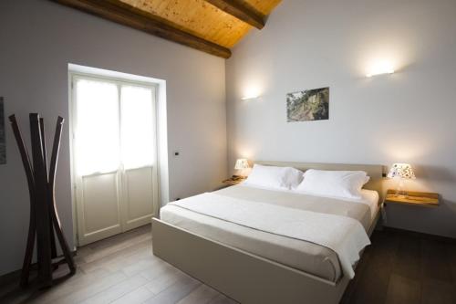 a bedroom with a large white bed and a window at Ca'Rapulin in Calosso
