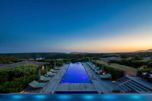 a swimming pool at night with lounge chairs at Hôtel & Spa Version Maquis Citadelle in Bonifacio