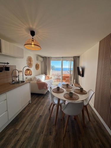 une cuisine et un salon avec une table et des chaises dans l'établissement Nautica - Appart 4 personnes vue mer, idéal famille, à Théoule-sur-Mer