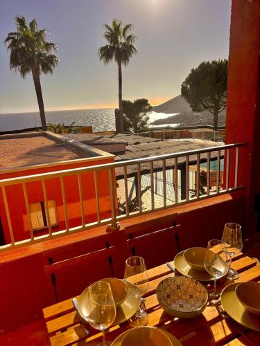 - une table avec des assiettes et des verres sur un balcon donnant sur la plage dans l'établissement Nautica - Appart 4 personnes vue mer, idéal famille, à Théoule-sur-Mer