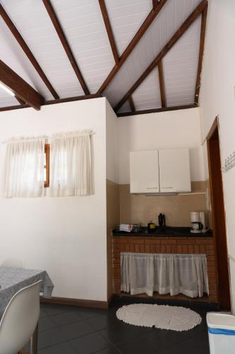 a kitchen with white walls and wooden ceilings at Mansão Adalgisa in Osasco