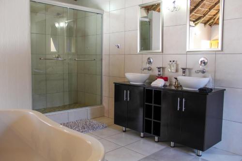a bathroom with two sinks and a shower at Tava Lingwe Game Lodge & Wedding Venue in Parys