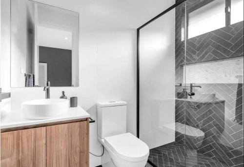 a bathroom with a toilet and a sink and a shower at Modern Ensuite with Private Side Entry in Annangrove