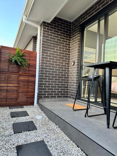 a table on a patio with a brick wall at Modern Ensuite with Private Side Entry in Annangrove