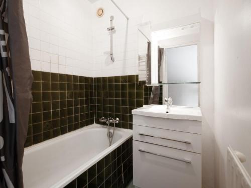 une salle de bain avec une baignoire blanche et un lavabo dans l'établissement Proche du port avec balcon - Kerlaouen, à Vannes