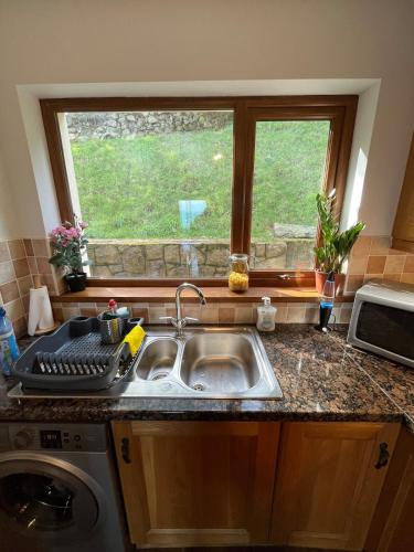 a kitchen counter with a sink and a window at Mourne Coastal Guesthouse in Newcastle