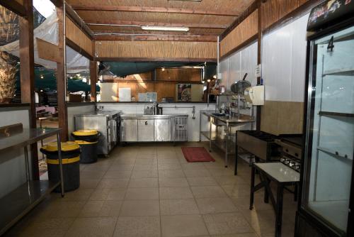 a large kitchen with stainless steel appliances in it at חאן שירת הערבה in Ẕofar
