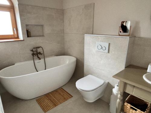 une salle de bain avec une baignoire, des toilettes et un lavabo dans l'établissement Le Domaine du Pin, à Romans