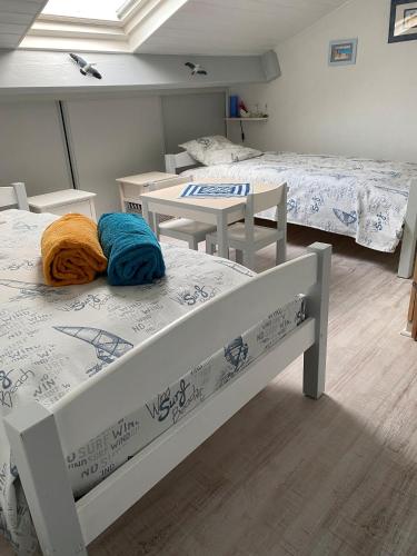 une chambre avec deux lits, une table et des chaises dans l'établissement 36 - Maison intime 4p, plage à pied, à Pornic
